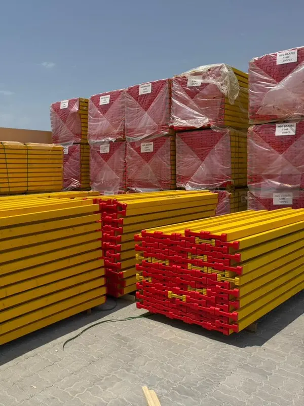 Stacks of yellow H20 timber beams with red end caps in front of wrapped packs